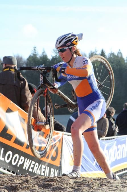Sabrina Stultiens carries her bike up the hill