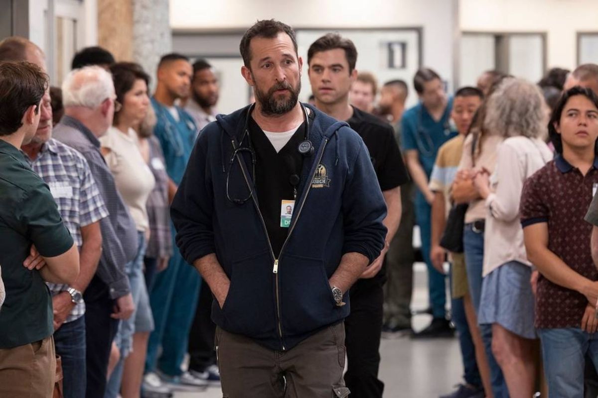 Noah Wyle and Patrick Ball walk through lines of people in their hospital in The Pitt S1 E8 -&quot;2:00 P.M.&quot;