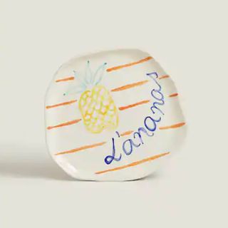 White Zara home plate with pineapple painted on it.