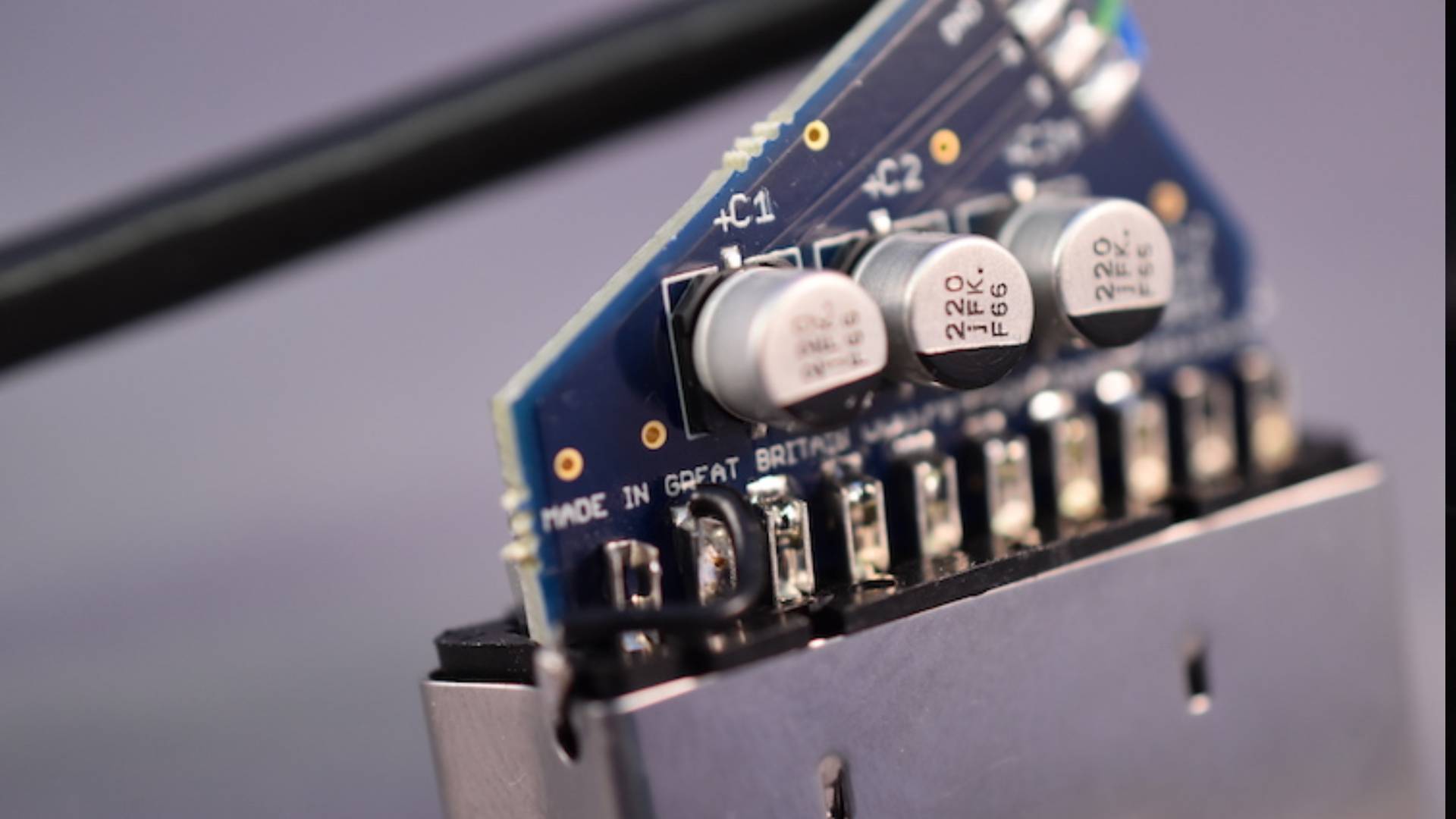 Photo of inside a Retro Gaming Cables RGB SCART with blue PCB connected to pins with components in view.