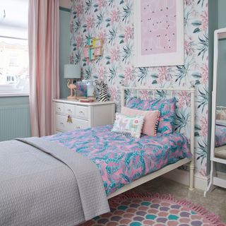 pink kids bedroom with wallpaper on wall and bed