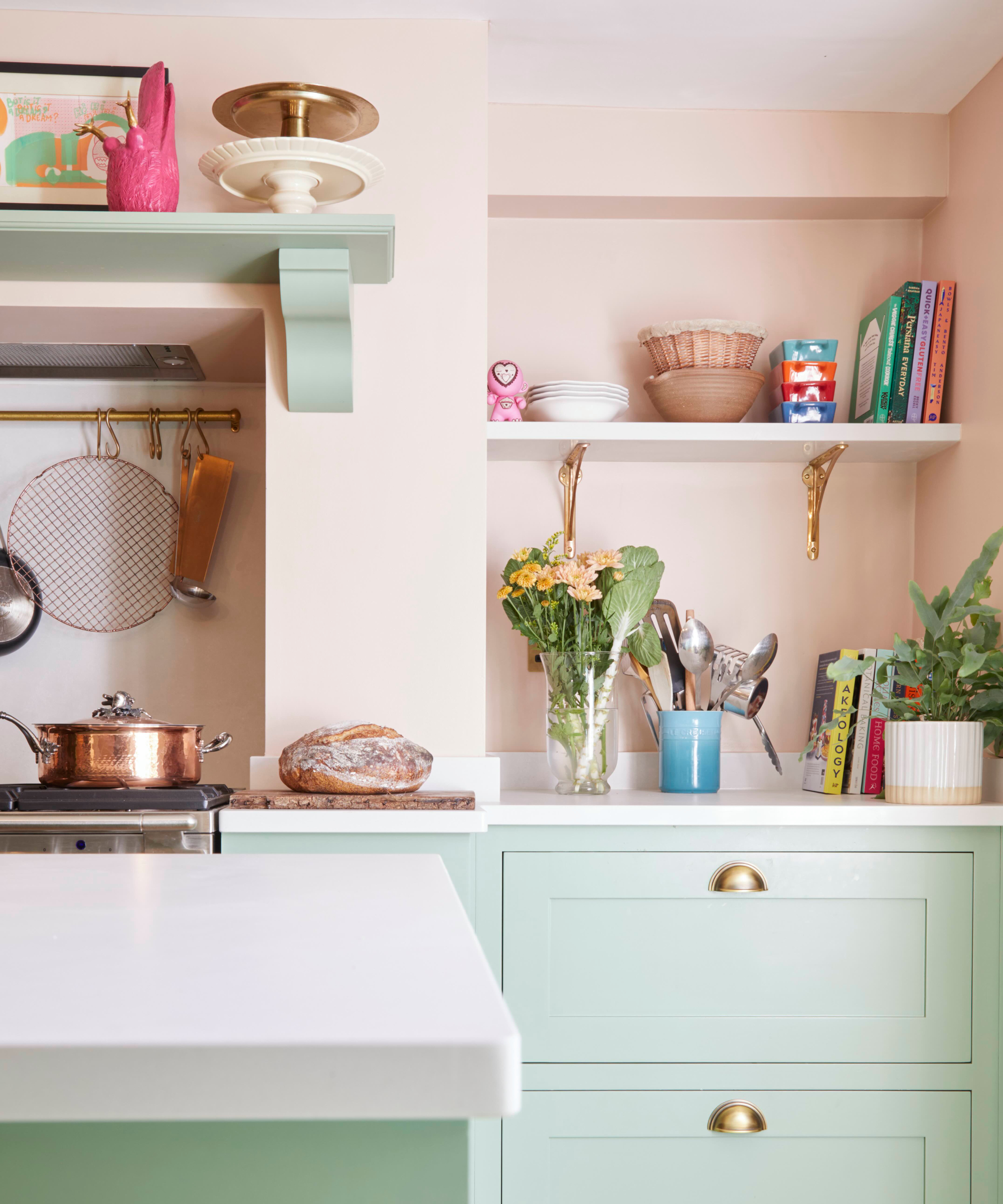 kitchen with light sage green cabinets and pink painted walls