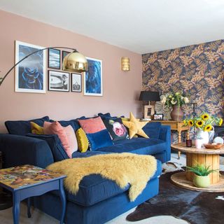 living room with wallpaper and frame on wall with blue sofa
