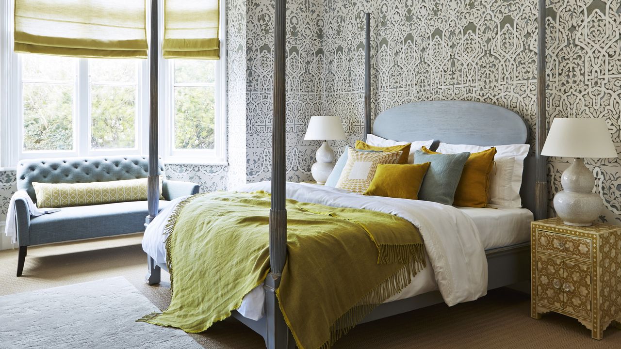 four poster bed with grey patterned wallpaper