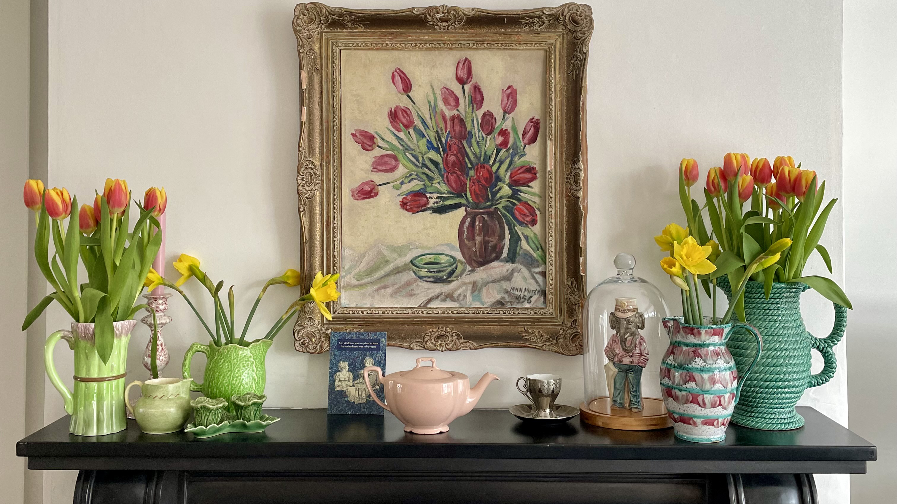 black mantlepiece with vintage vases holding flowers