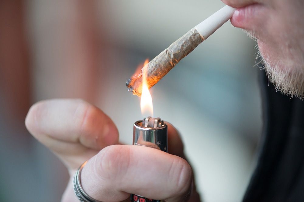 Man smoking marijuana cigarette soft drug in Amsterdam, Netherlands.