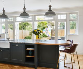 kitchen island with curved end and pendant lights above