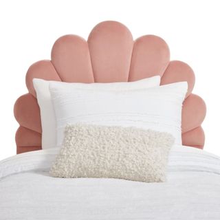 A pink shell headboard with white bedding