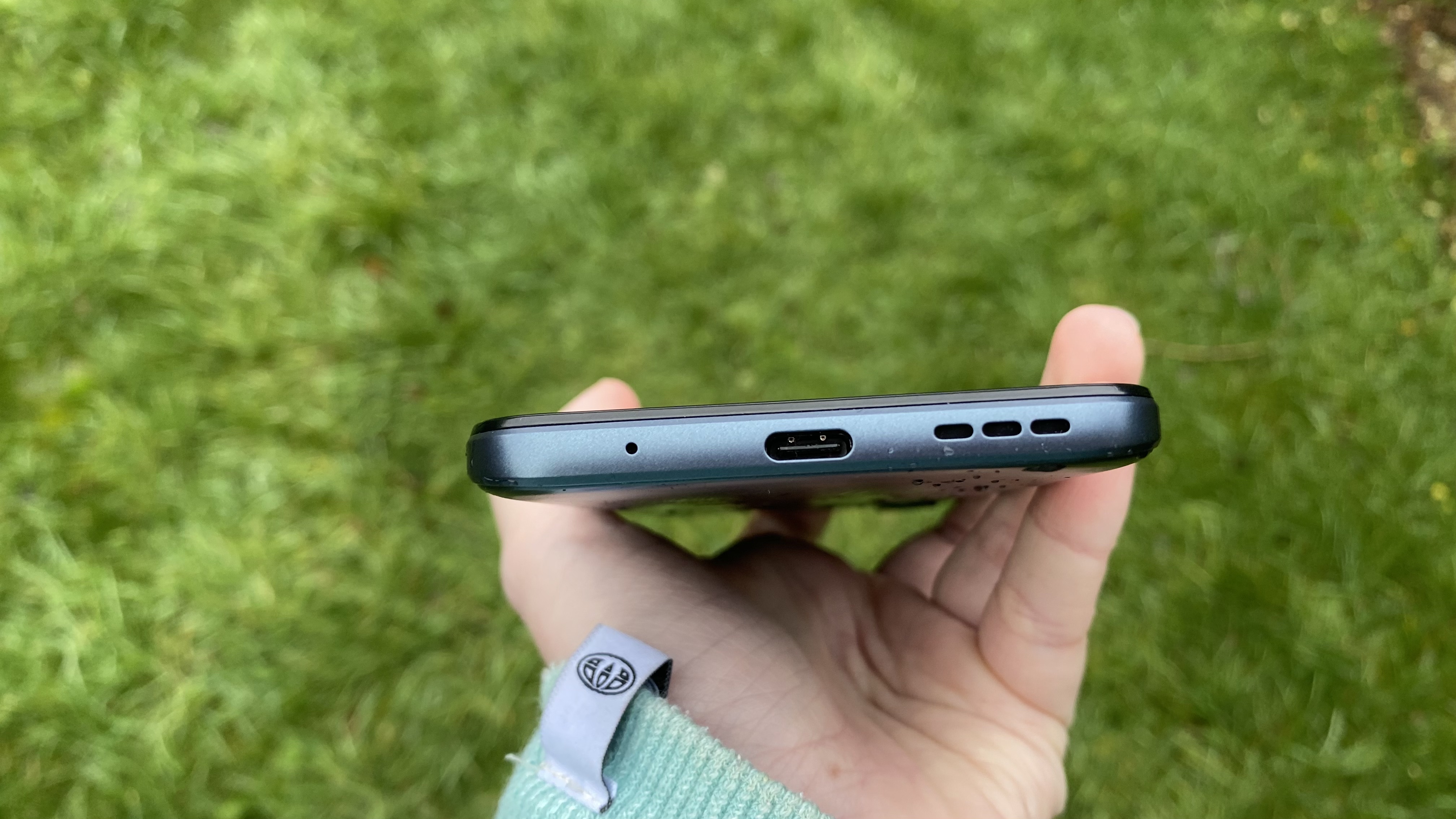 A Moto G31's bottom edge, in someone's hand