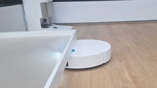 Dreame X50 Ultra Complete robot vacuum driving under a low table