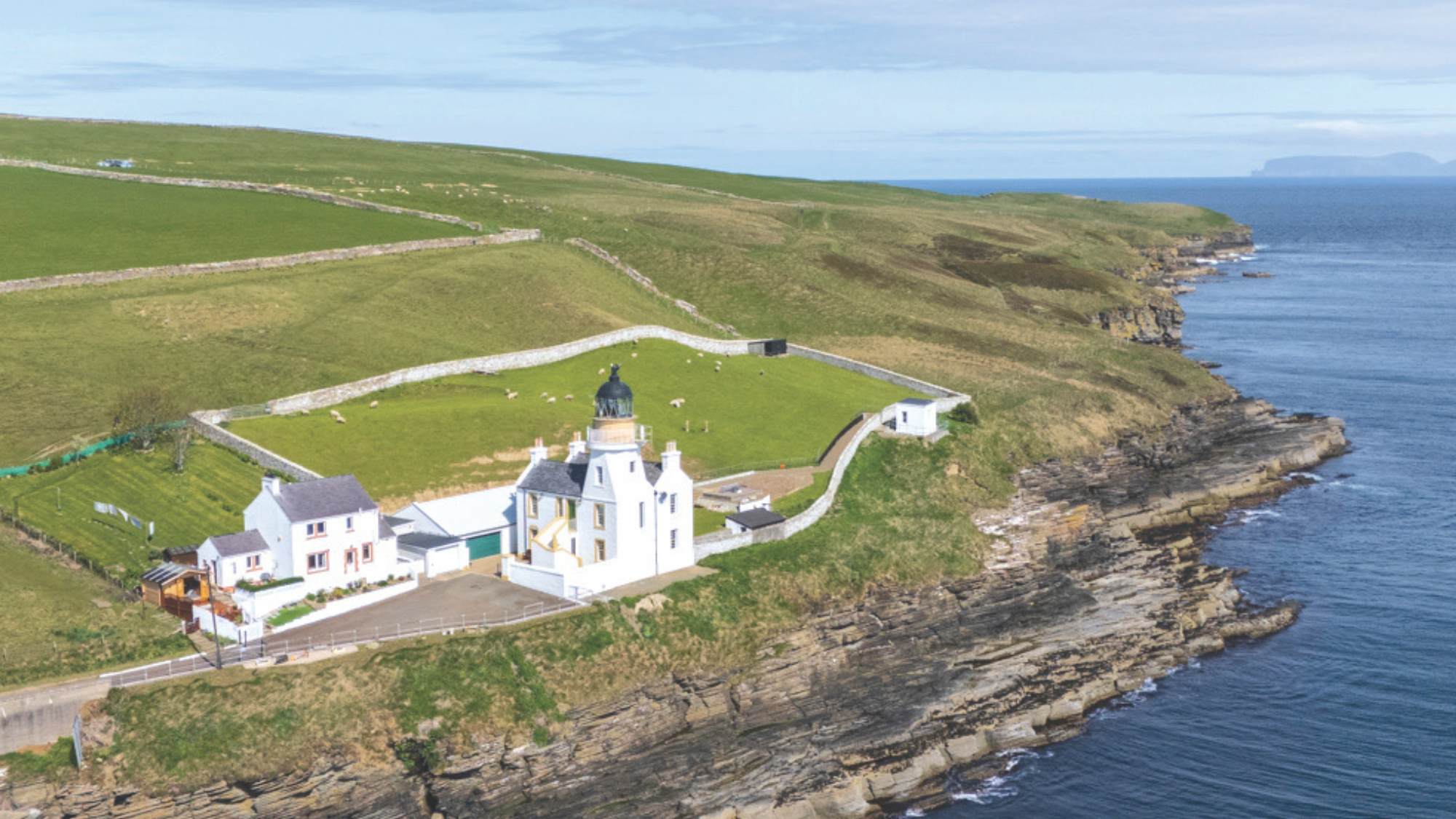 A striking white lighthouse and tower overlooking the Pentland Firth.