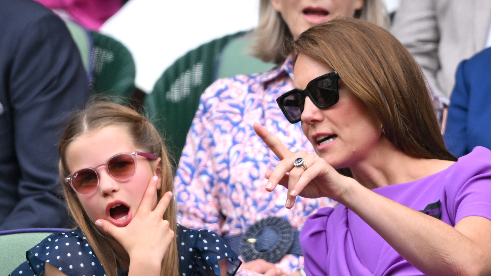 Princess Charlotte looks shocked while wearing a navy and white polka dot dress at Wimbledon, as her mom Kate Middleton points