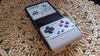 GameSir Pocket Taco on wicker table cover attached to Asus ROG Phone 8 Pro with Pokemon gameplay on screen featuring Charmander and Squirtle.