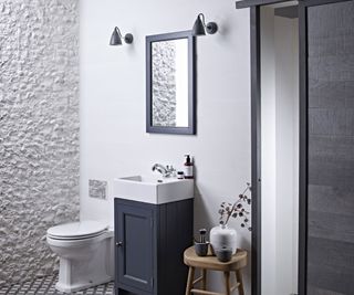 white bathroom with blue vanity unity unit and bathroom wall lights