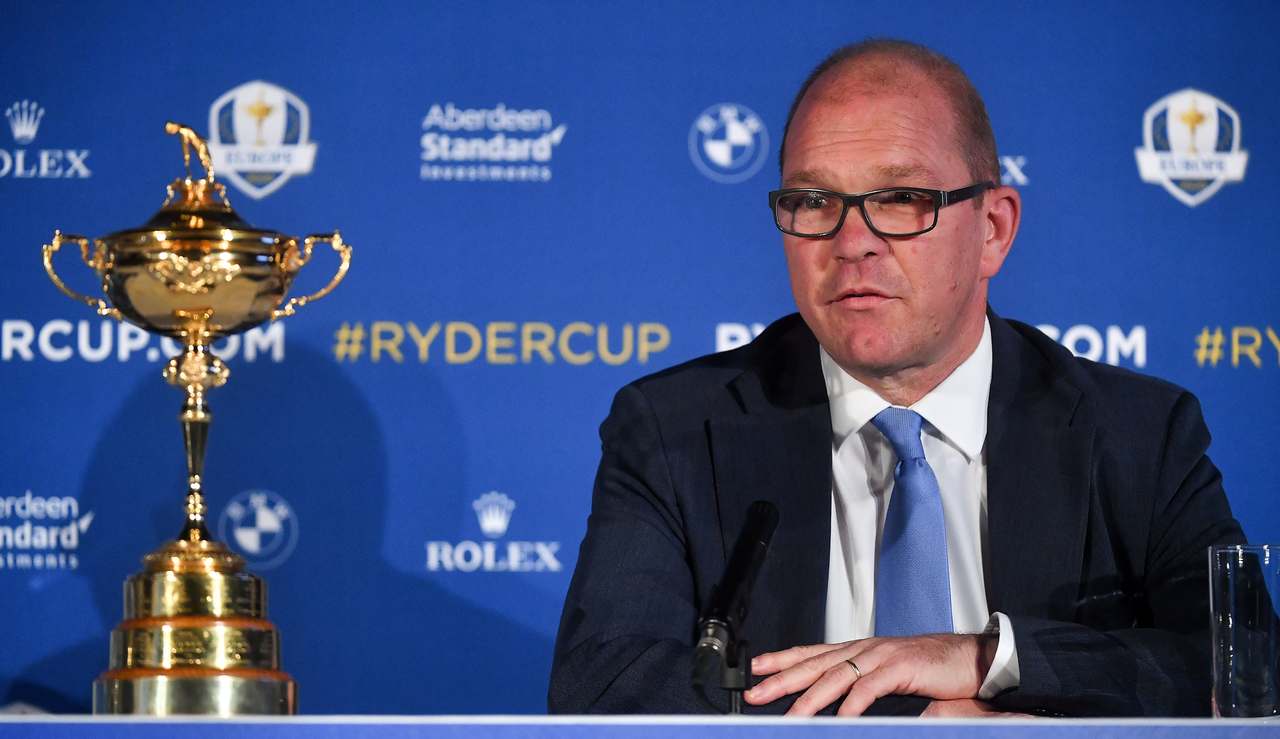 Guy Kinnings talks to the media, with the Ryder Cup beside him