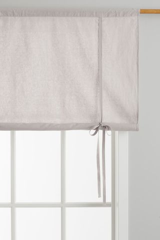 grey linen blinds half rolled up over a window