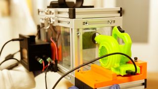 a researcher holds up a prototype of a breathalyzer device that detects diseases