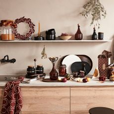 IKEA Krosamos collection, in a rustic kitchen with autumnal-coloured kitchenware on white floating shelves