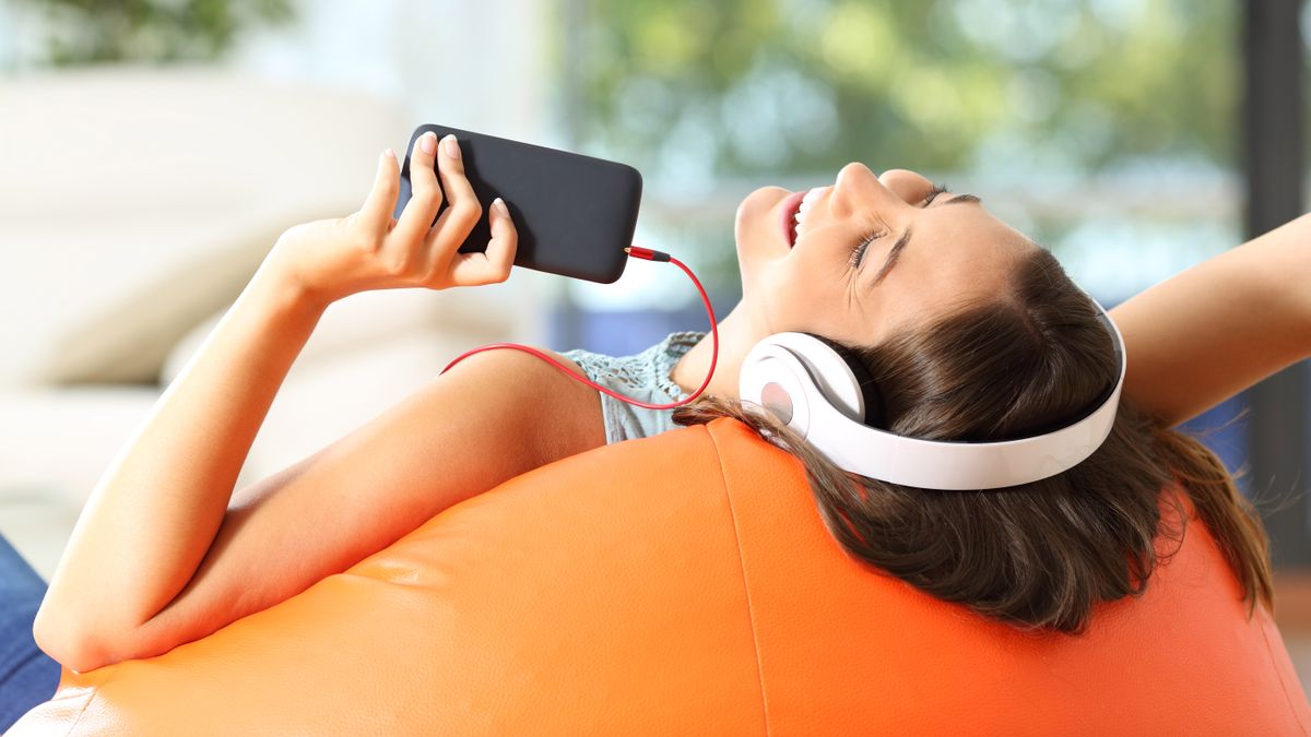 Young woman listening music with headphones