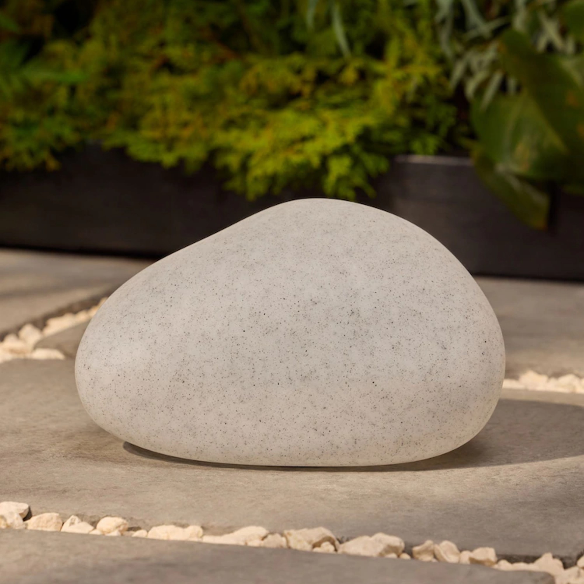 Next Natural Pebble Outdoor Solar Light on a patio during the day