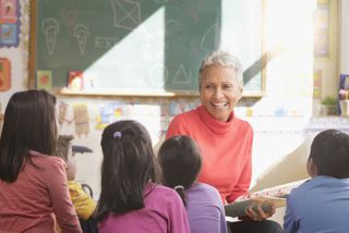 A woman teaches some school children