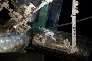 Spacewalking astronauts transfer the RRM to a temporary platform on the ISS in July 2011.