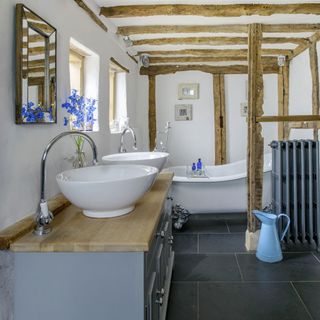 bathroom with wooden ceiling beams and bathtub