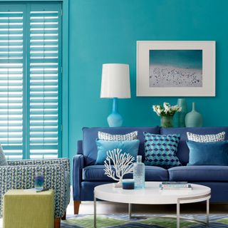 living room with blue sofa and shutters