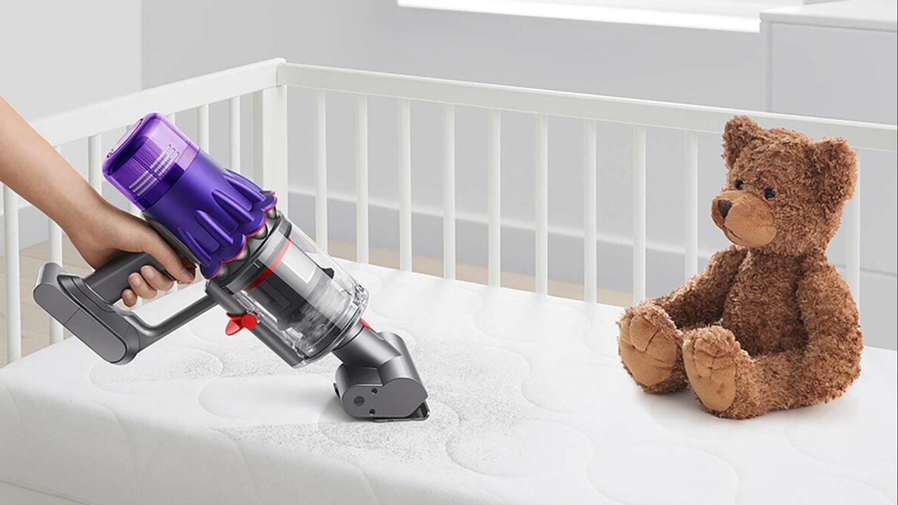 A handheld Dyson vacuum used for cleaning a kid&#039;s mattress