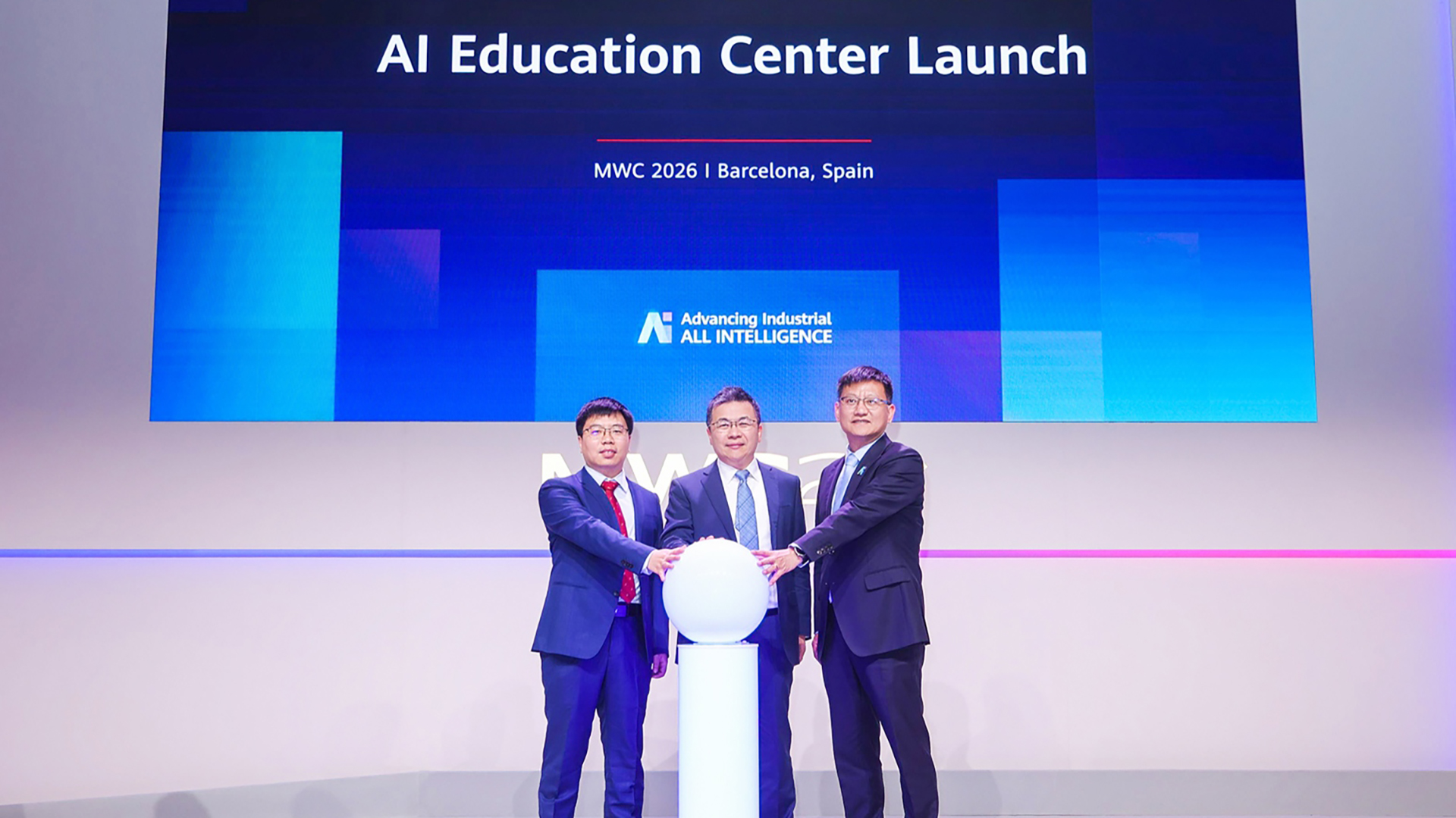 Three Huawei representatives on stage with their hands on a white ball at the launch of the AI Education Center at MWC 2026