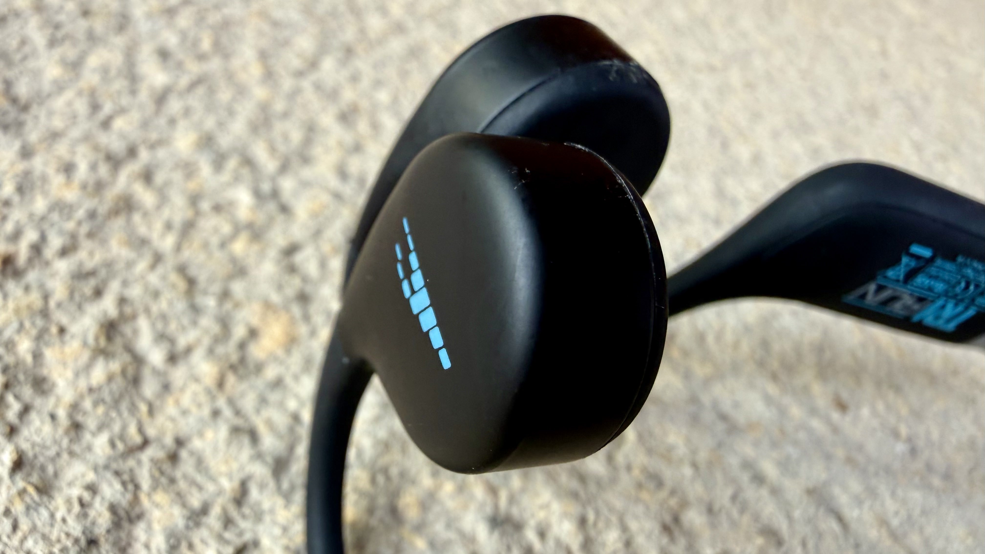 the h2o audio tri run bone conduction headphones on a stone surface