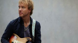 Kenny Wayne Shepherd looks off to his left as he sits with his heavily aged Fender Stratocaster