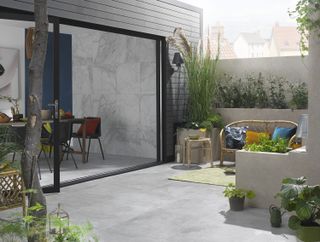indoor outdoor space with pale coloured paving and bi-fold doors