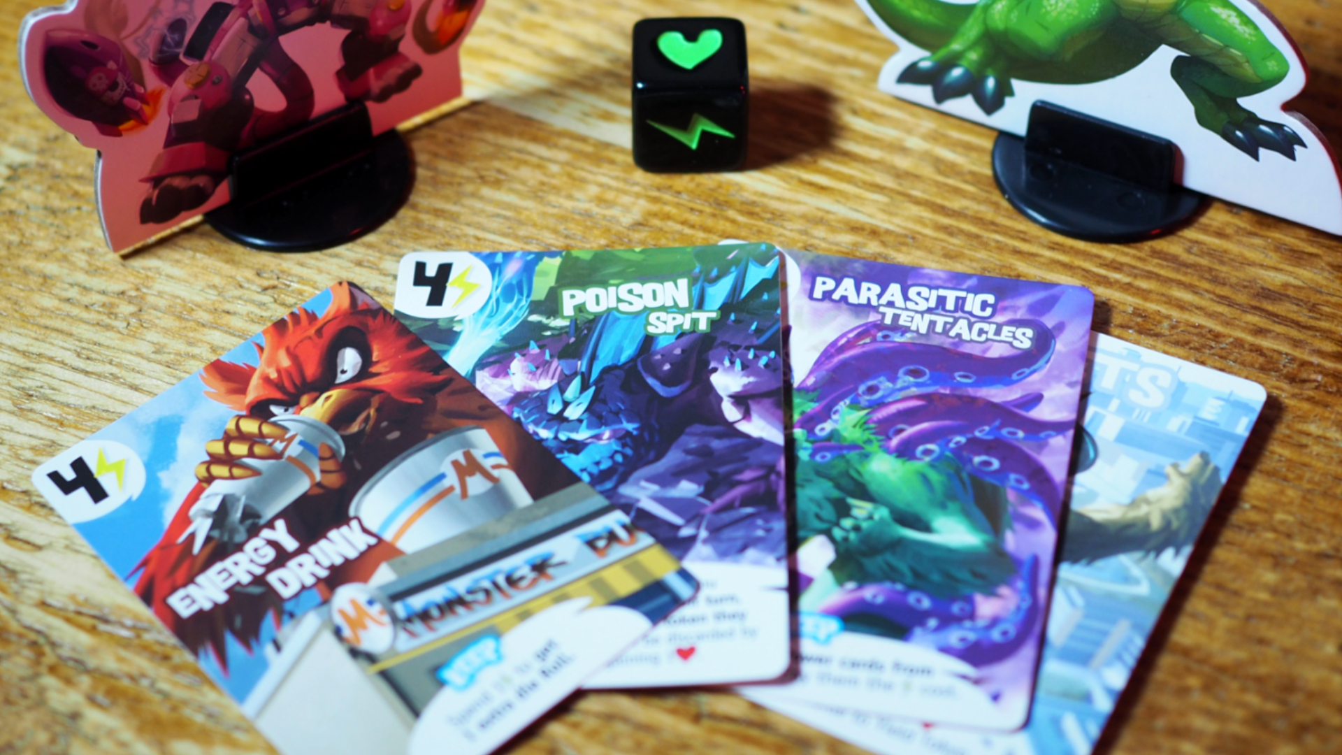 King of Tokyo tokens and cards against a wooden table