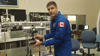 Canadian astronaut Jeremy Hansen shows off a model of the International Space Station during a tour at the Canadian Space Agency headquarters near Montreal.