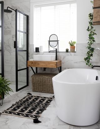 modern contemporary bathroom with crittall style shower screen, white freestanding bath and minimalist storage basket