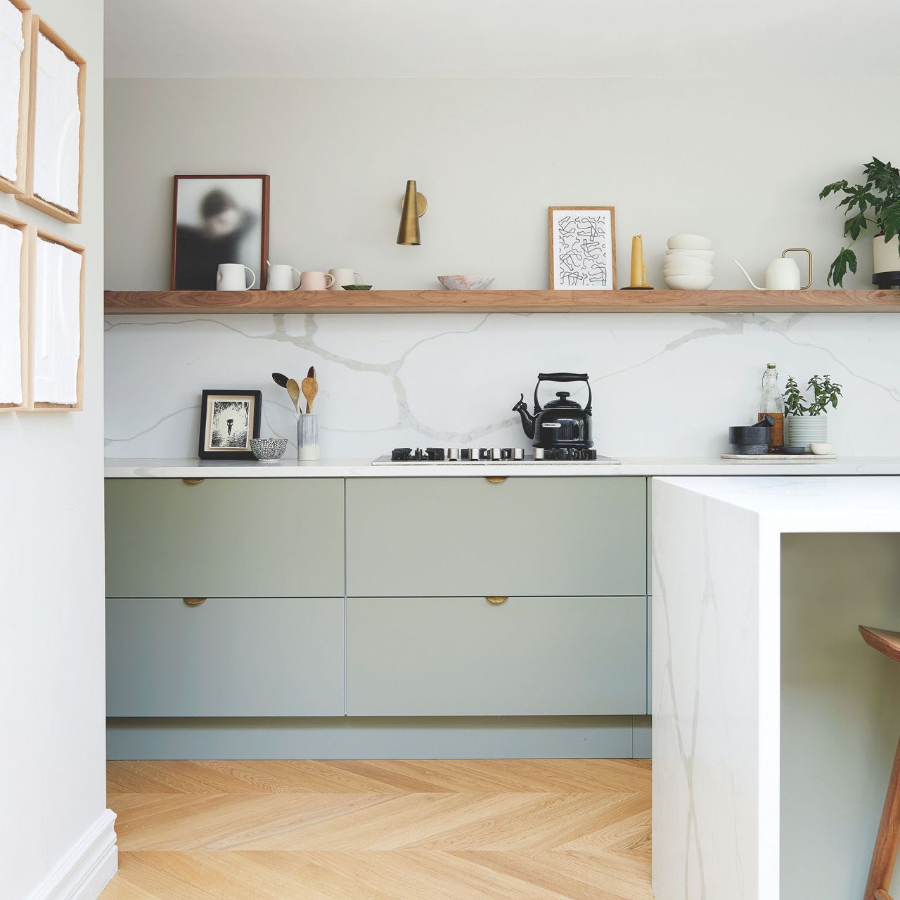 White painted kitchen with marble backsplash and light green cupboards underneath