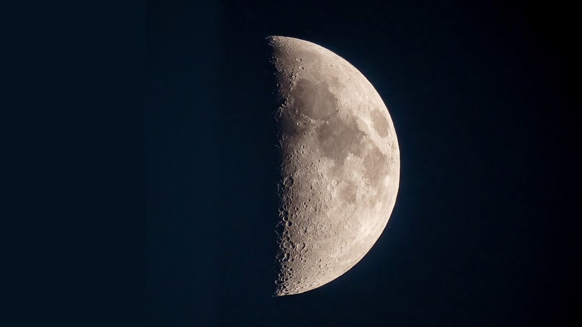 a half-lit moon in a dark sky