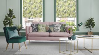 sage green color trend in living room with botanical print roller blinds behind blush pink sofa