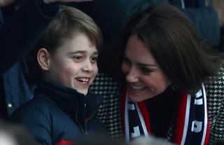 Prince George of Cambridge talks to his mother Catherine, Duchess of Cambridge as they attend the Six Nations international rugby union match