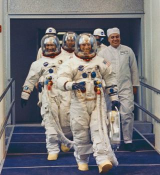 Apollo 12 astronauts Pete Conrad (front) Richard Gordon (left) and Alan Bean (center top in background) walk out to the Astovan for the trip to the launch pad at NASA's Kennedy Space Center in Florida ahead of their Nov. 14, 1969 launch.