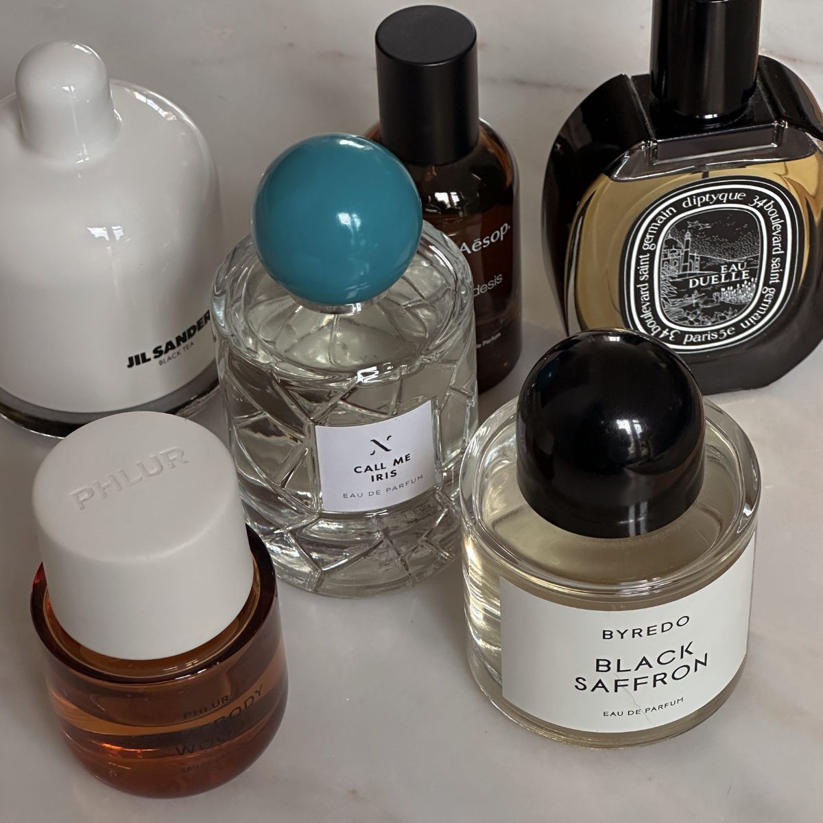 A photo of perfume bottles on a marble table