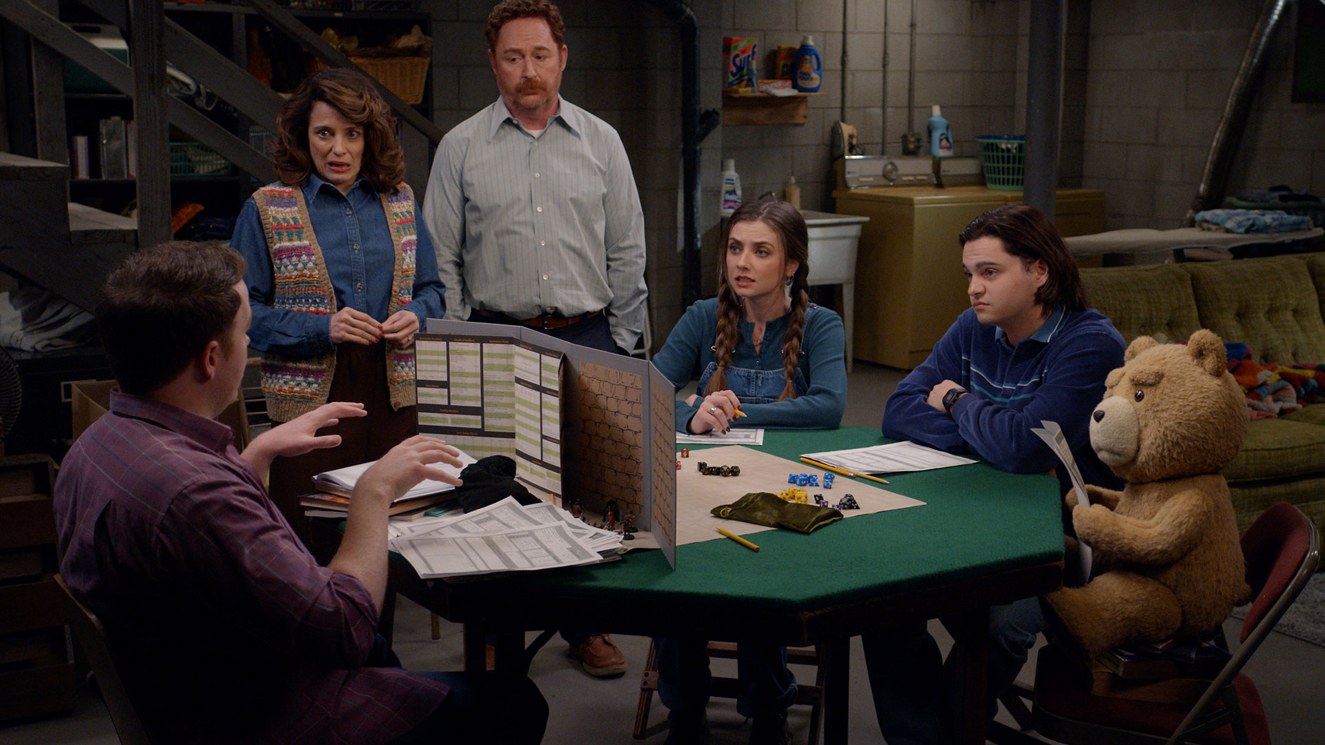 The characters of Ted season 2 sit around a table 