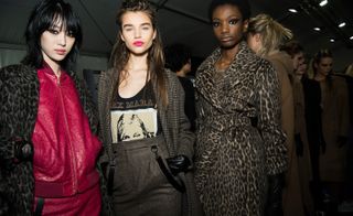 Model wears a fuchsia ostrich bomber jacket suit, others are dresses in check and leopard print coats