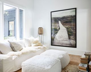 White oversized sofa and pouffes in a small living room