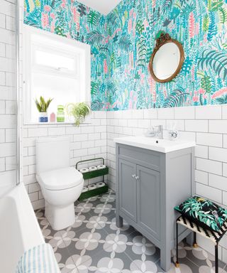 Bright bathroom with patterned wallpaper, white metro wall tiles and patterned floor tiles