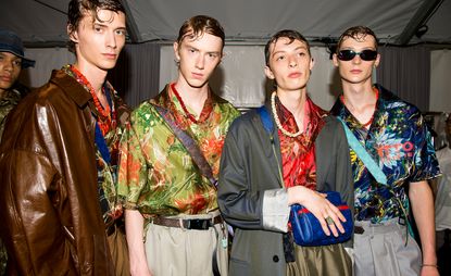 4 models stand together posing for the camera wearing colourful patterned shirts