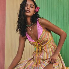 Model wearing Free People clothing in front of a colourful wall