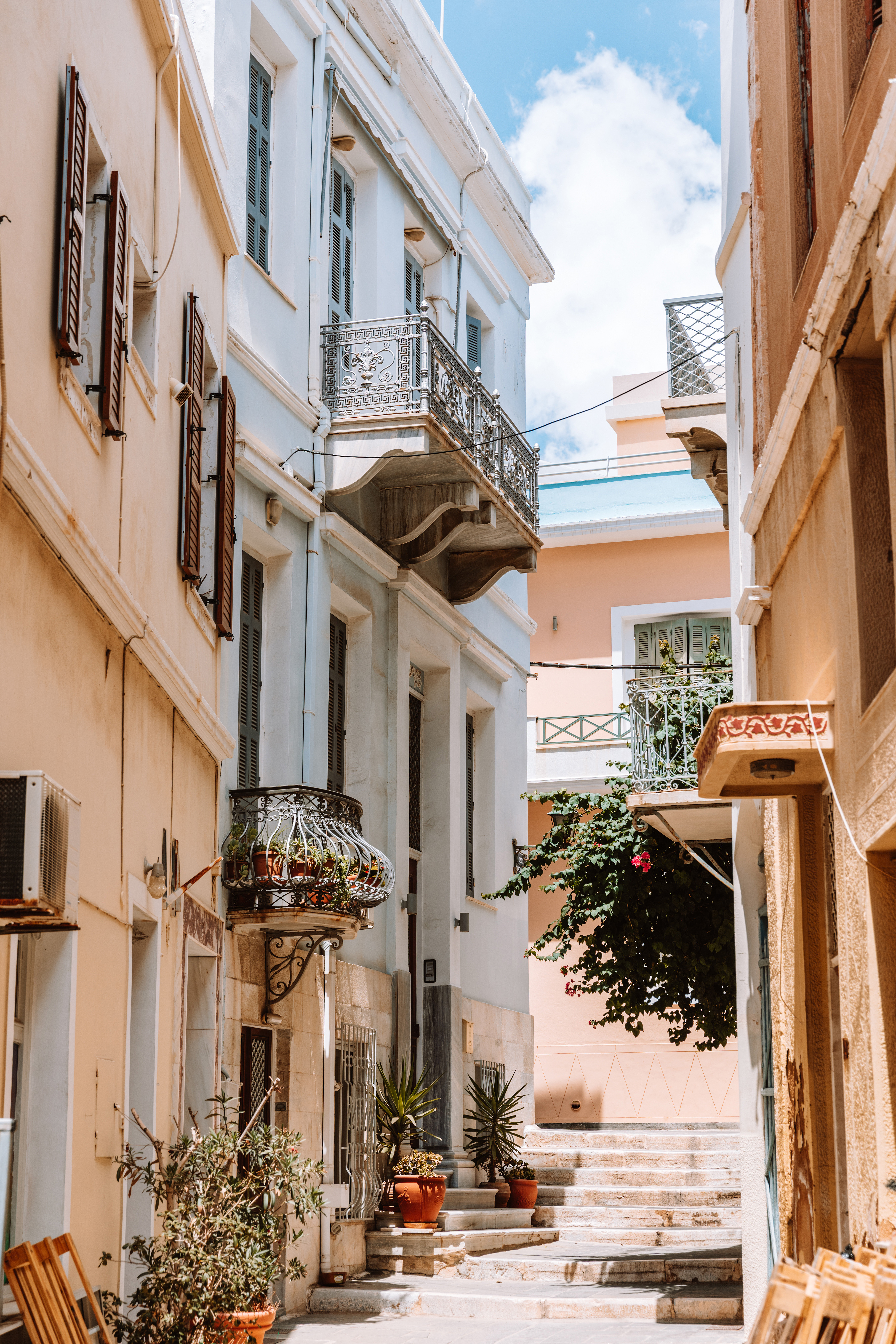 Pastel house facades in a narrow street in Syros