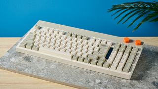 The Lofree Block keyboard on a stone surface with a blue wall in the background.